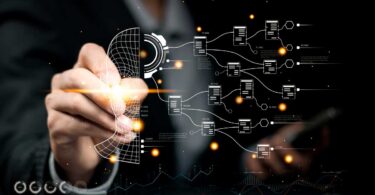 Mão digitando sobre tela digital com perfil virtual, fluxos de dados e bancos de informações conectados, representando o uso da automação inteligente e inteligência artificial para otimizar o marketing imobiliário.