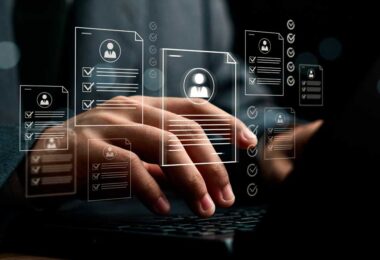 Mãos digitando em notebook com documentos digitais e checklists flutuando, representando o uso de inteligência artificial para captação, triagem e automação de leads no mercado imobiliário.