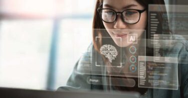 Mulher de óculos trabalhando no computador com hologramas digitais de IA, códigos e gráficos, simbolizando a implementação e uso prático de inteligência artificial para transformação e automação no mercado imobiliário.