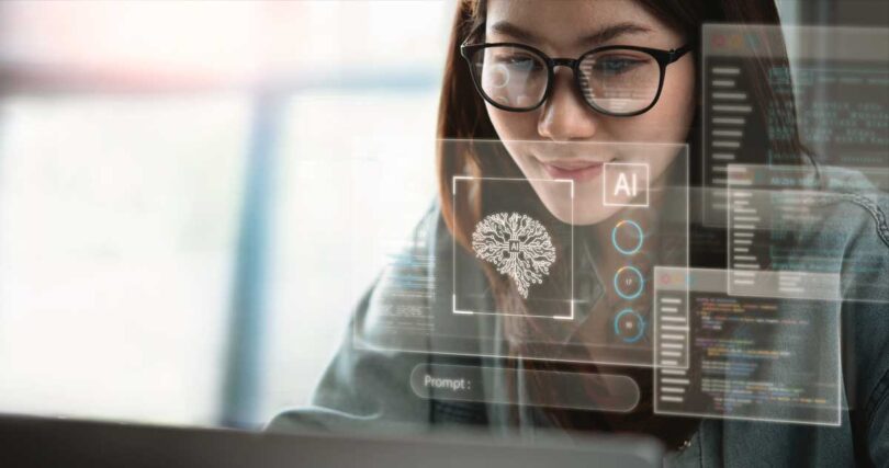 Mulher de óculos trabalhando no computador com hologramas digitais de IA, códigos e gráficos, simbolizando a implementação e uso prático de inteligência artificial para transformação e automação no mercado imobiliário.